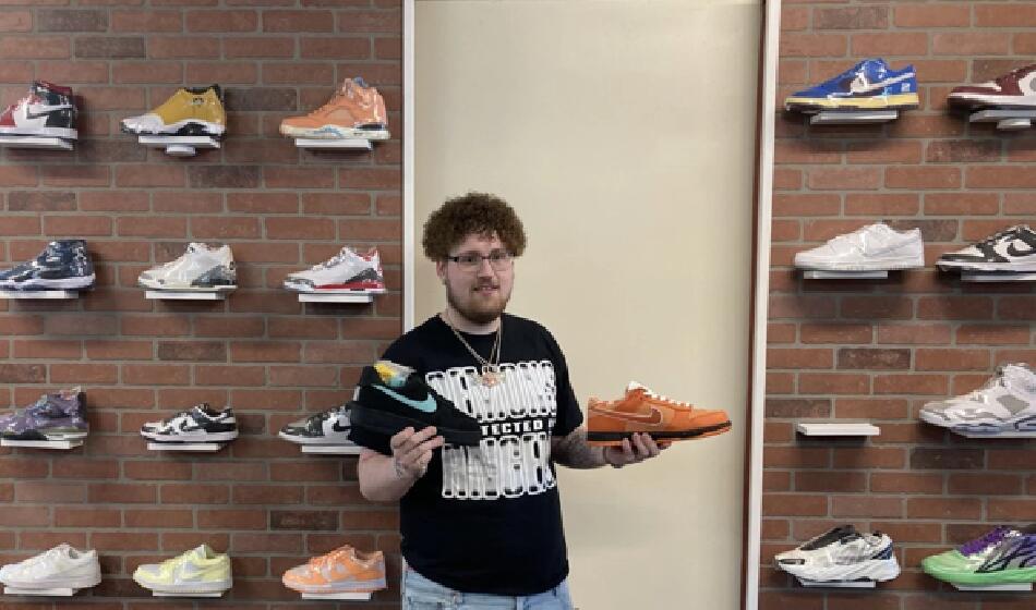 Eli Vaillancourt at the Filthy Kicks pop-up in front of a display of high-end shoes. 