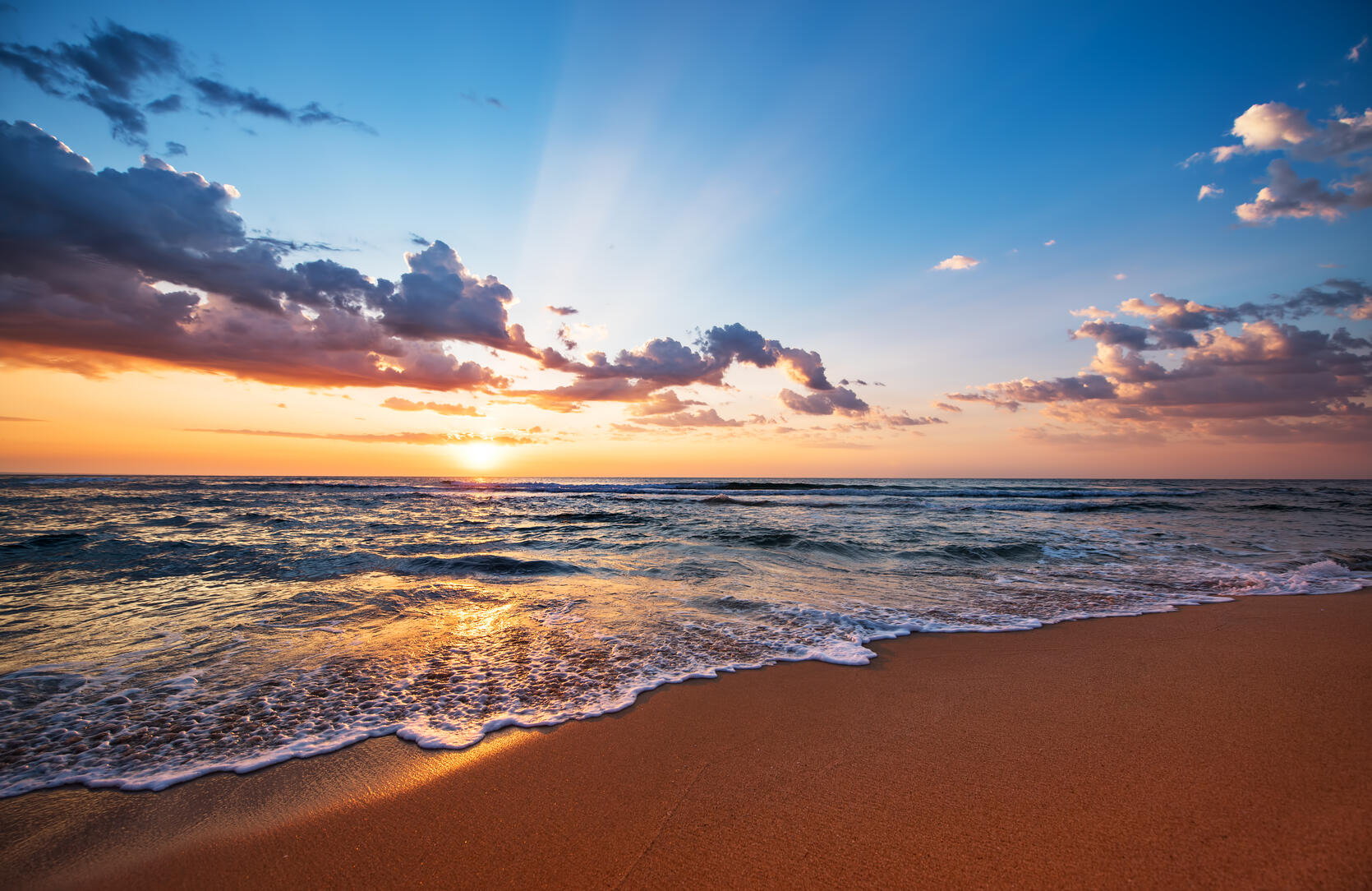 Photograph of vibrant sunset over the ocean.