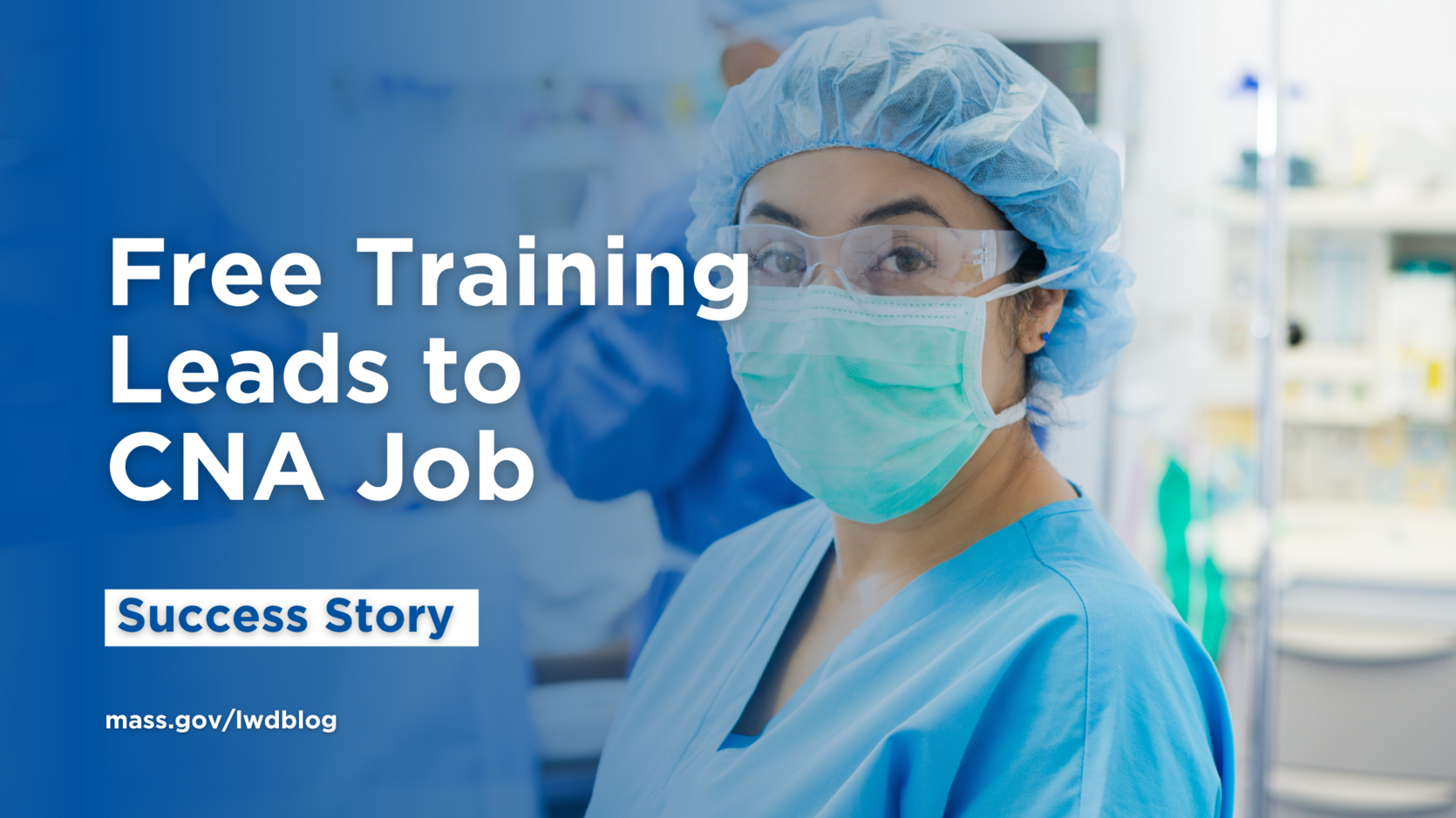 Picture of a nurse standing in an operating room wearing a medical mask, safety glasses, and blue scrubs. 