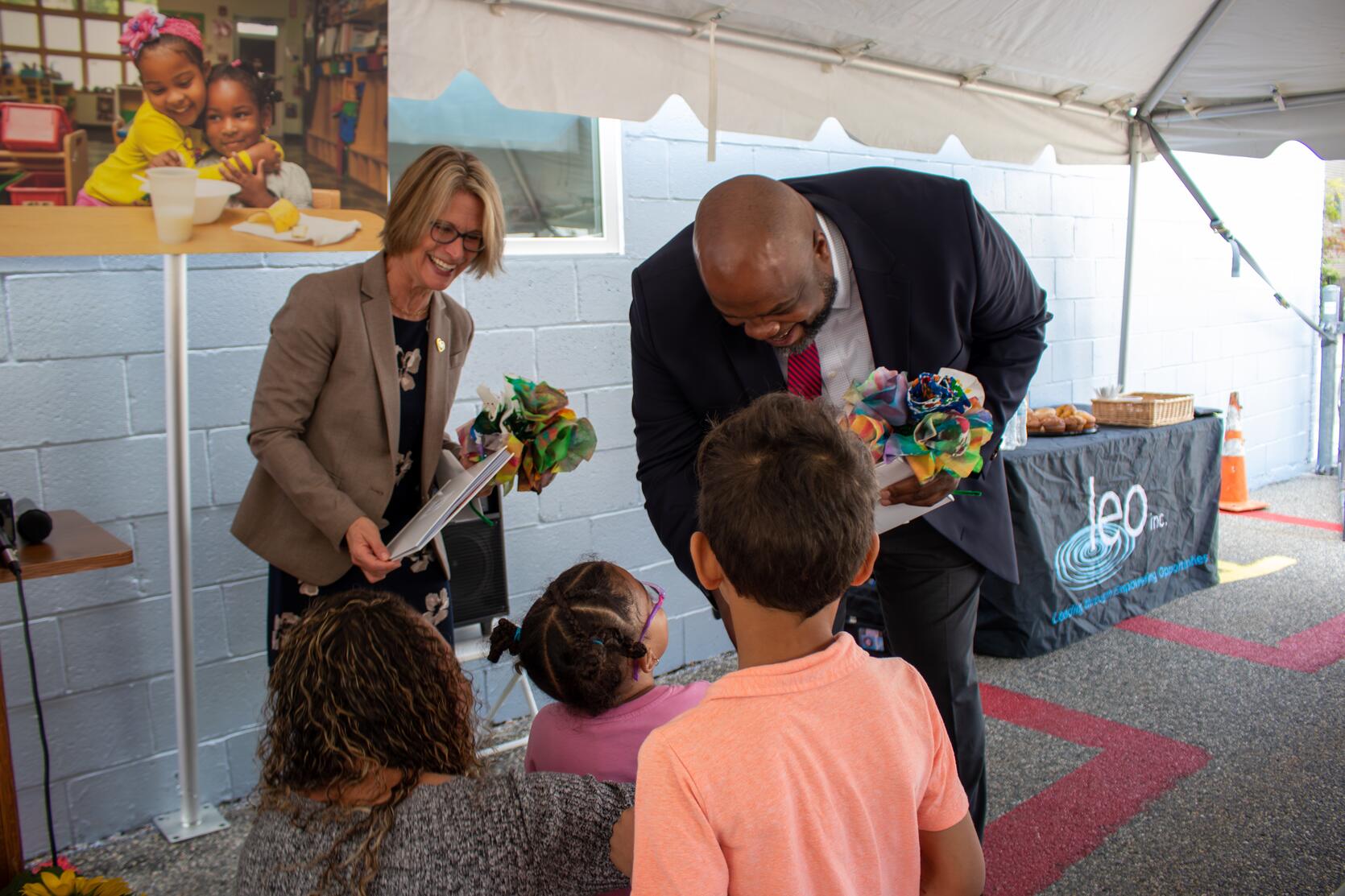 Secretary and Commissioner talking with children at the Leo Head Start program