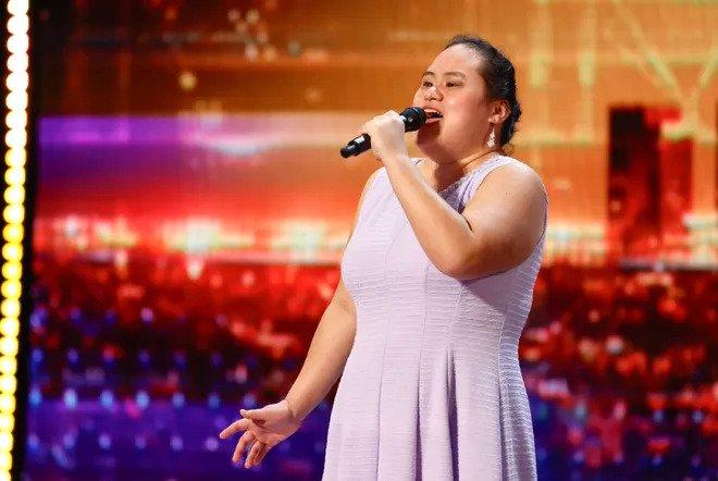 A photo of Lavender Darcangelo singing on the America's Got Talent stage