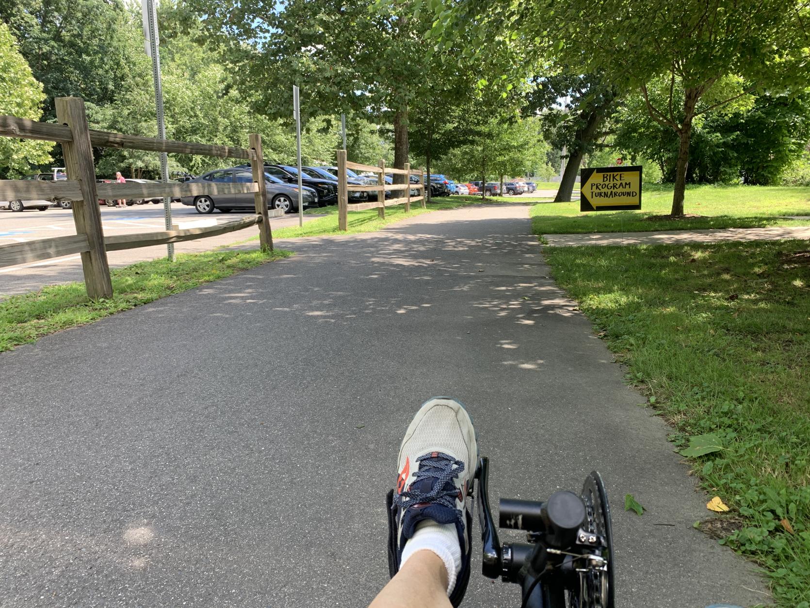 Point of View of individual riding an accessible cycle down a paved path 