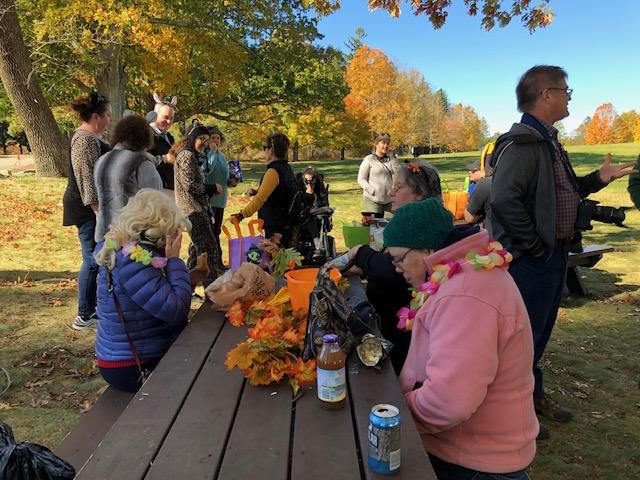 People wearing costumes at a picnic table.