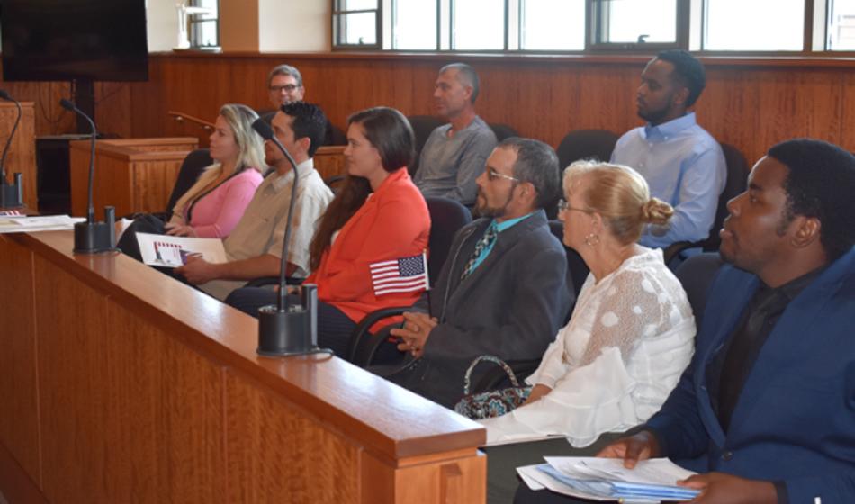 A group of people seated in a courtroom. 