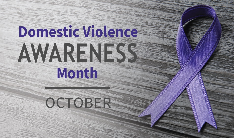 Purple domestic violence awareness ribbon on a wood background with text that says "Domestic Violence Awareness Month, October"