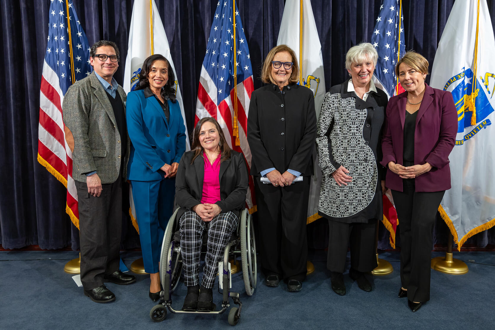 six women stand on stage