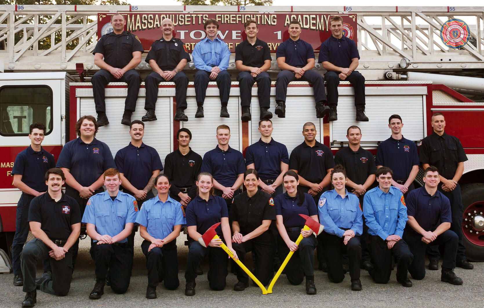 Photo of 25 firefighters on and around a ladder truck