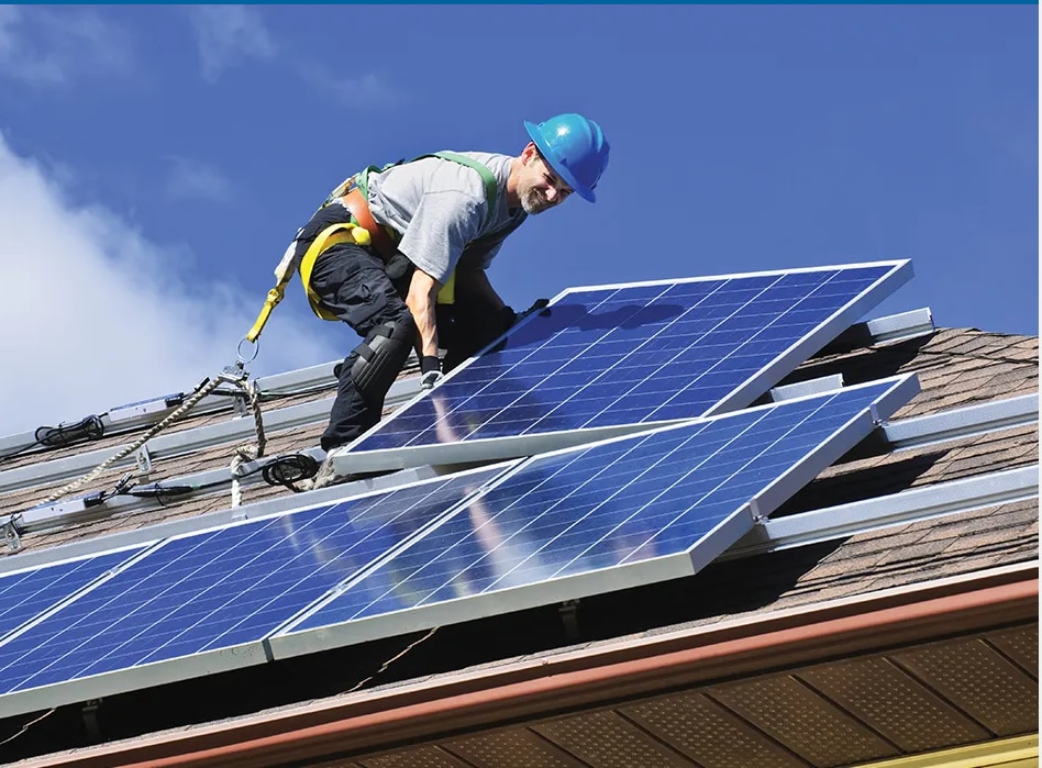 Worker installs solar panels on a rooftop