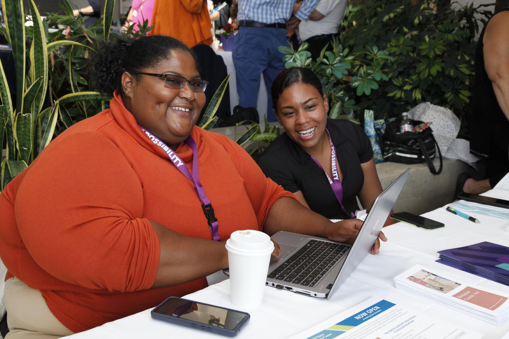 A photo of two women sitting and smiling at a table.