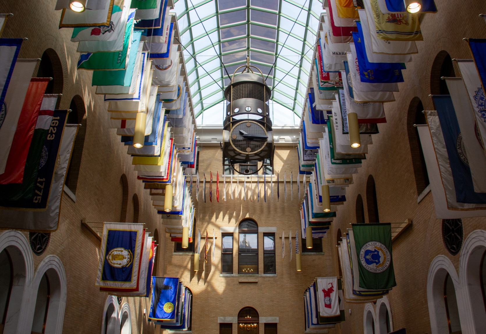 The Great Hall, a brick room with a glass ceiling and hundreds of flags hung.