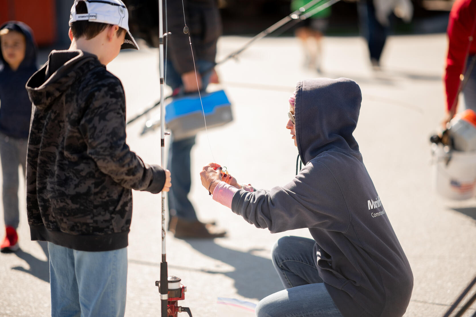 DMF staff member helping a young angler.