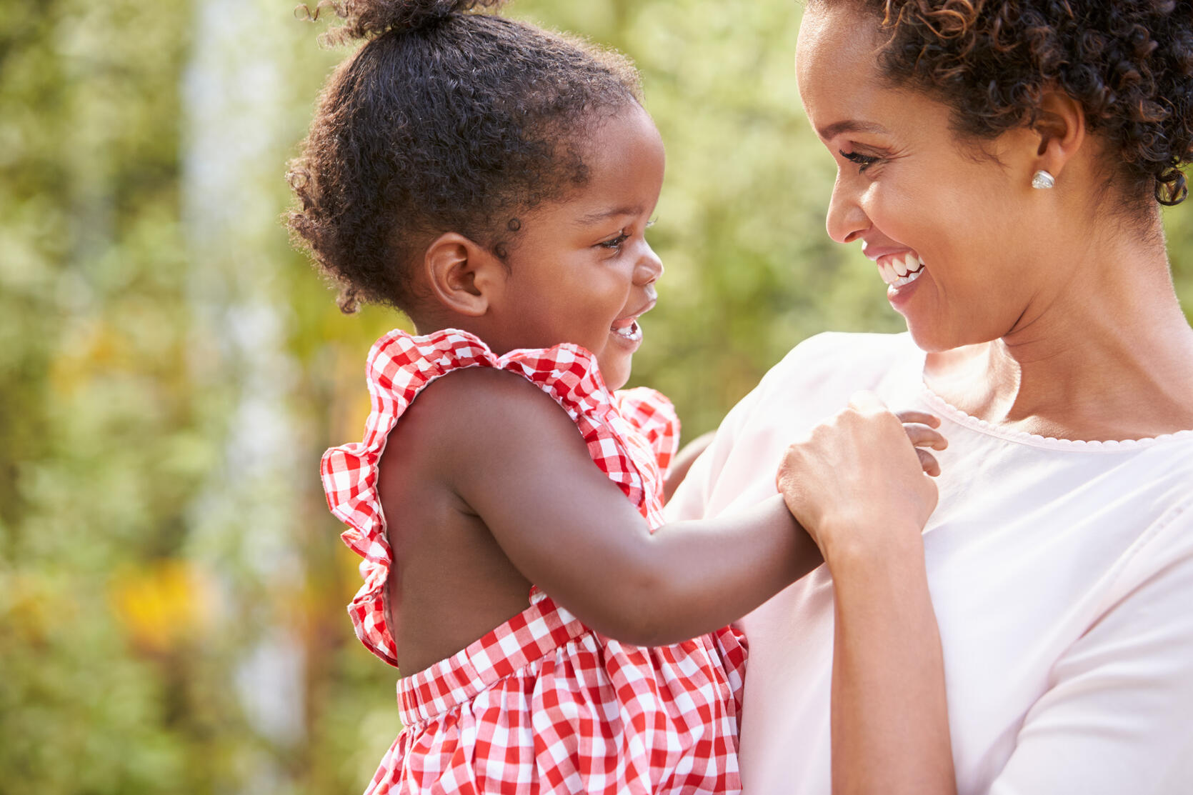 Photograph of happy mother holding her happy child.