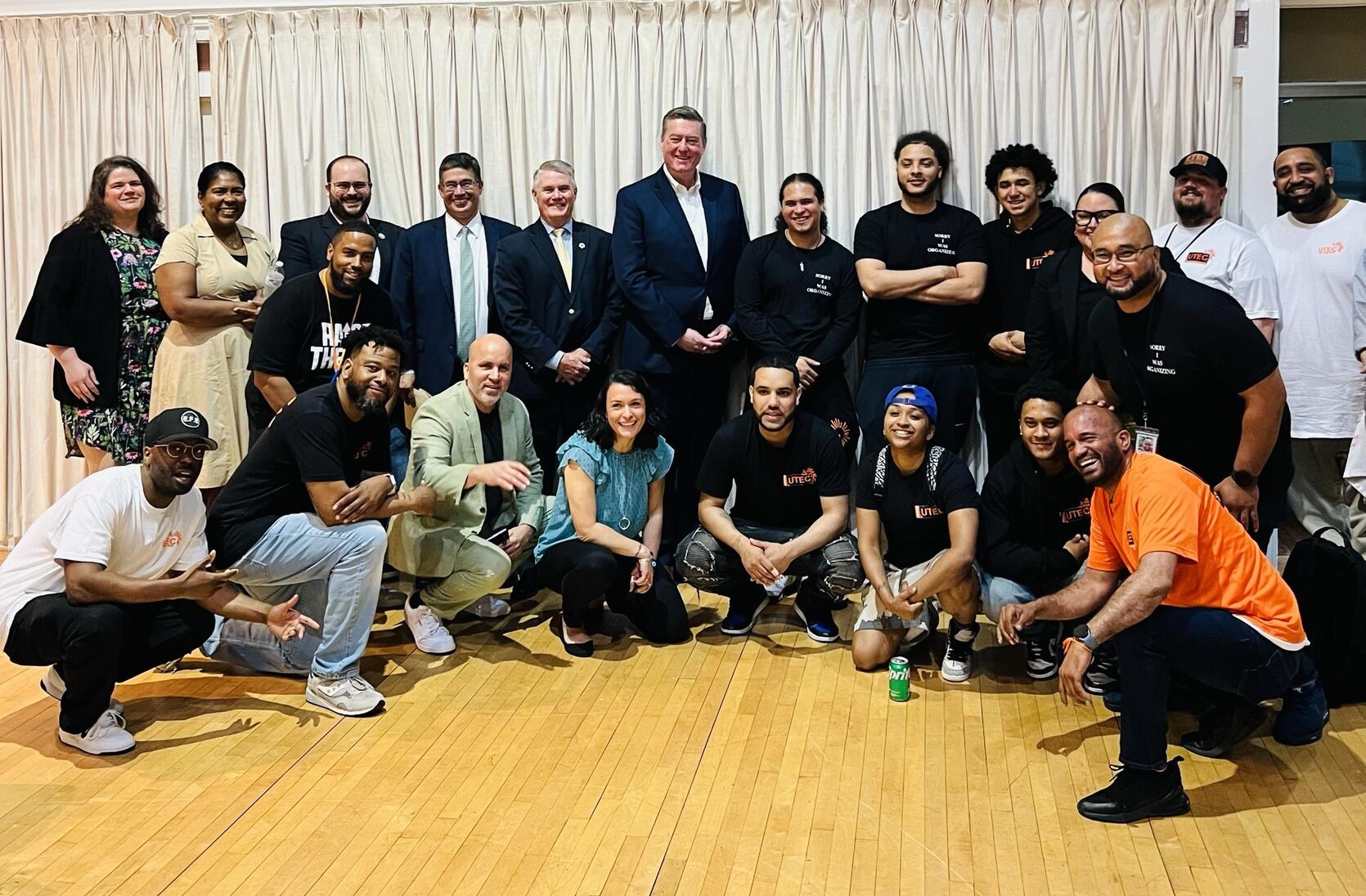 Secretary Ed Augustus and Secretary Terrence Reidy pose with young adults from Lowell, Lawrence and Haverhill.