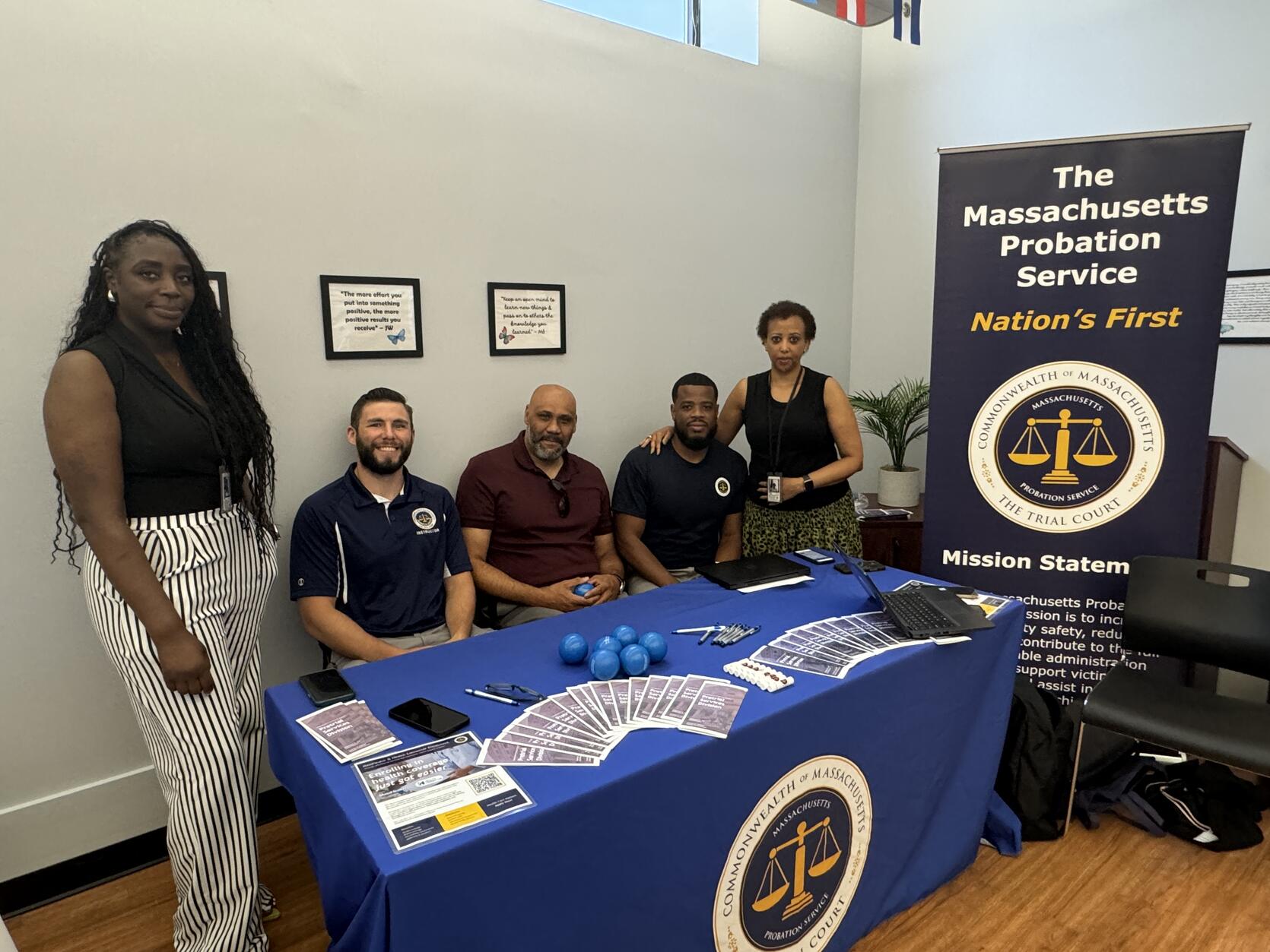 Pretrial Services Division employees at the job fair with a sign that reads: The Massachusetts Probation Service.