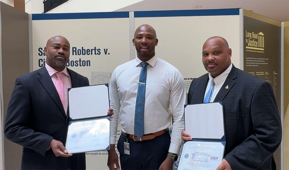 Probation officer standing with his two supervisors and their awards