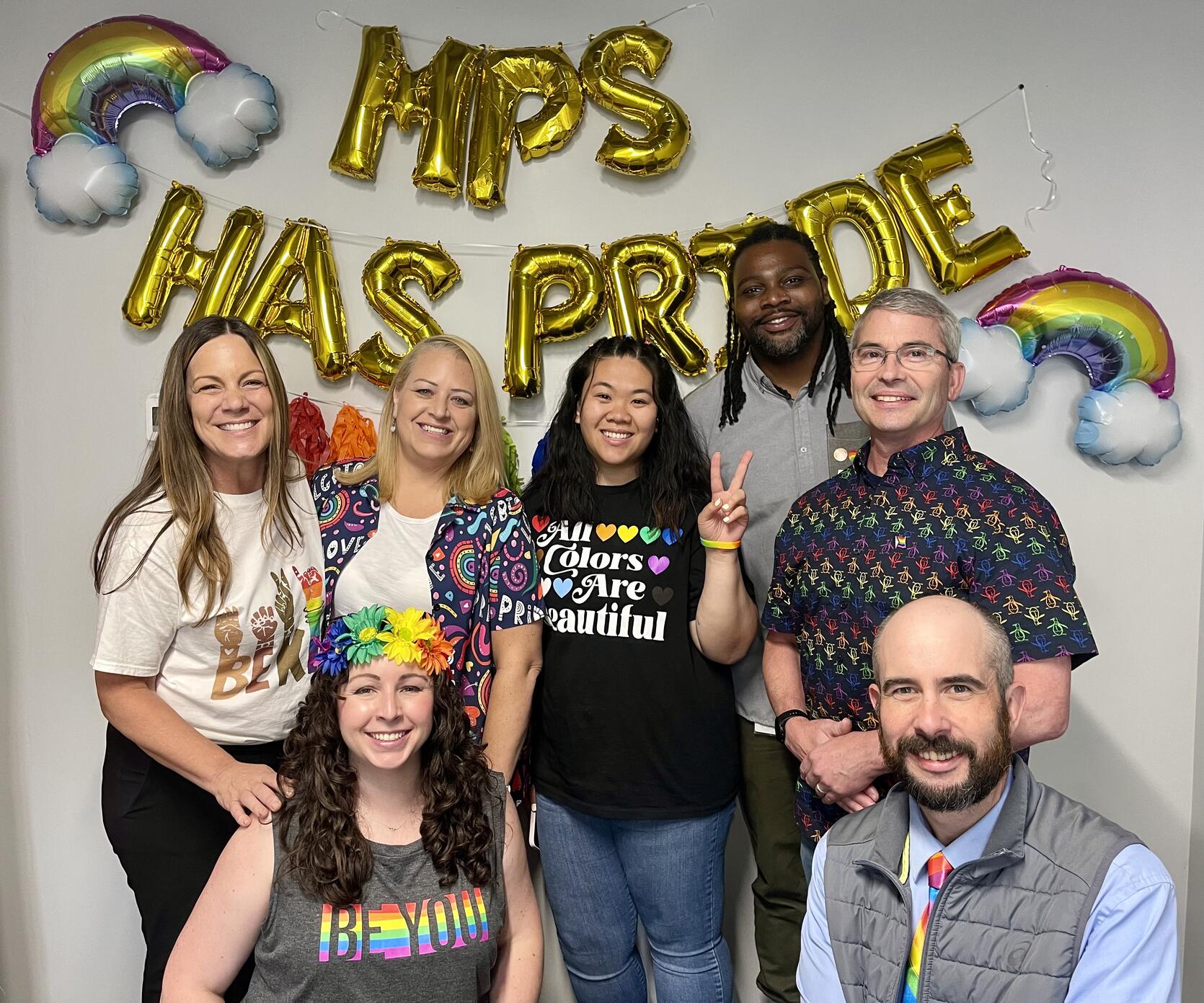 MPS staff standing in front of Pride Day decorations