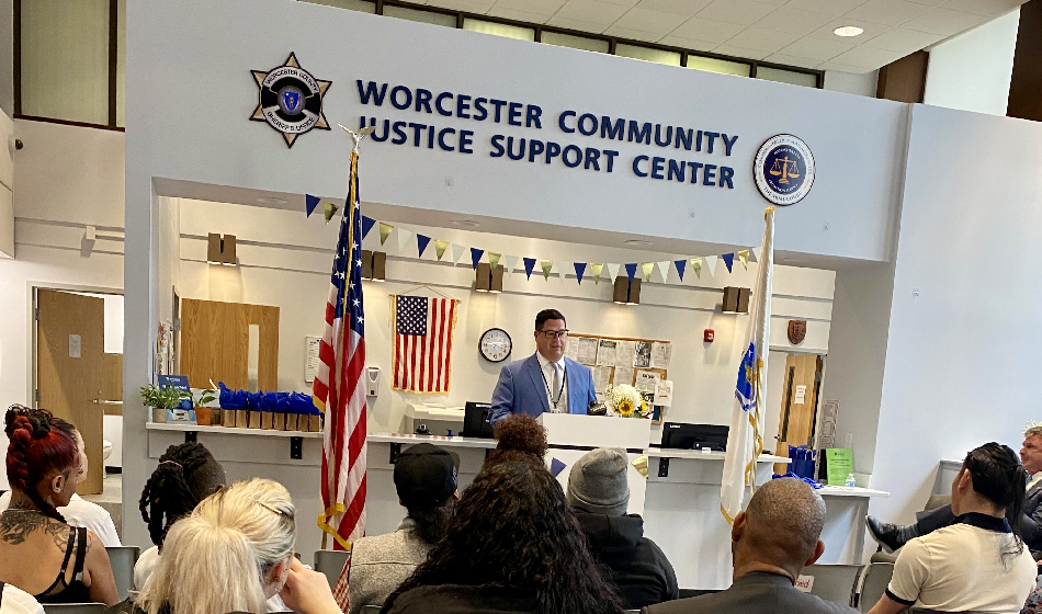 A man delivers remarks to a crowd from behind a podium. 