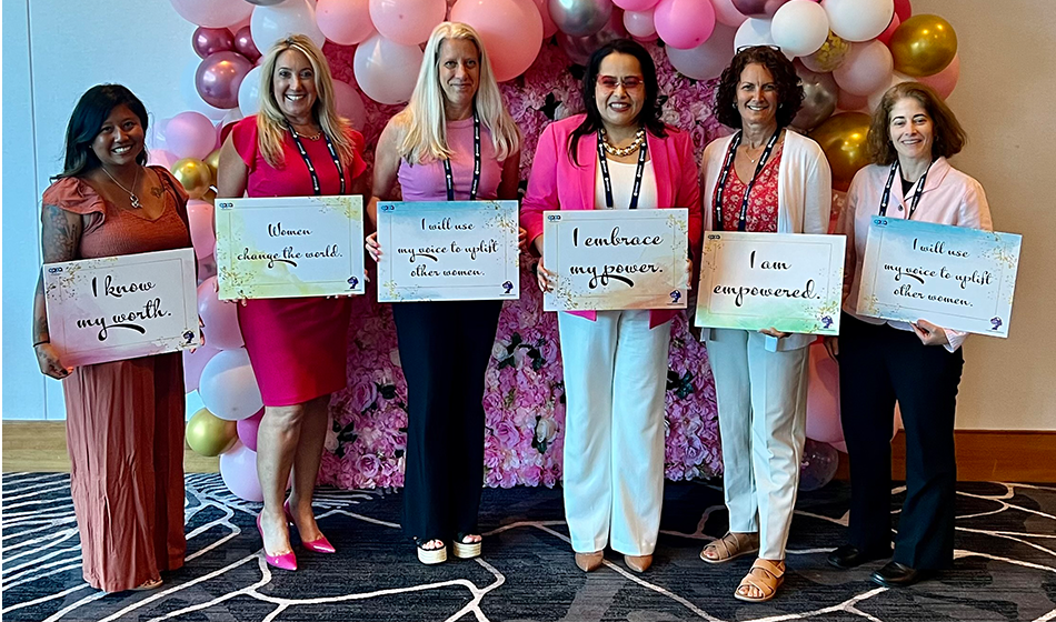 Probation employees and colleagues hold empowerment signs at the Third Annual Women's Symposium