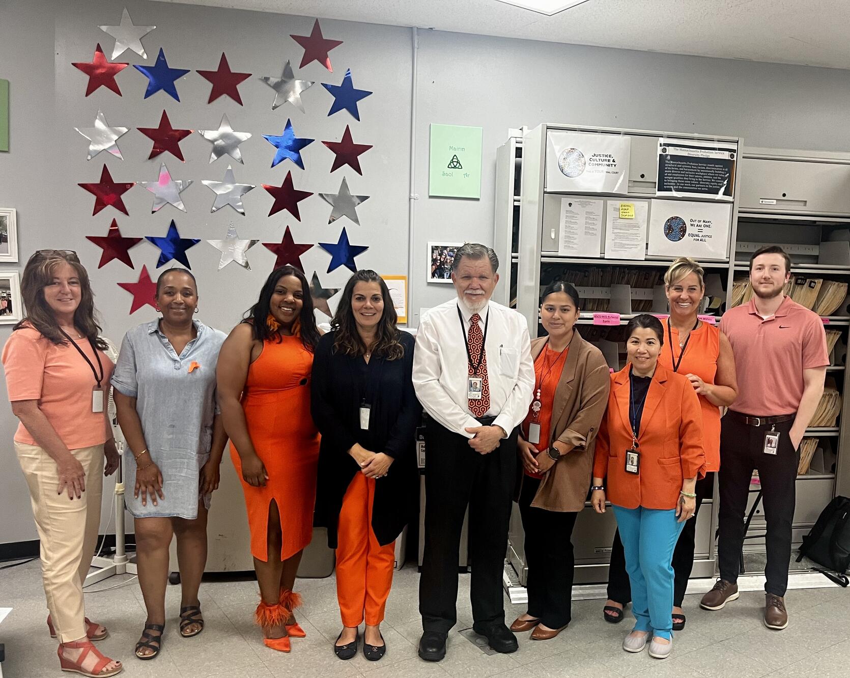 Quincy District Court probation staff standing in front of a wall decorated with red, blue, and silver stars.