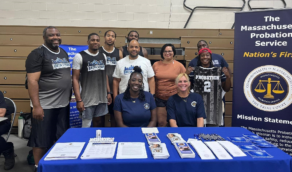 A group of people pose for a picture with a Massachusetts Probation Service banner next to them