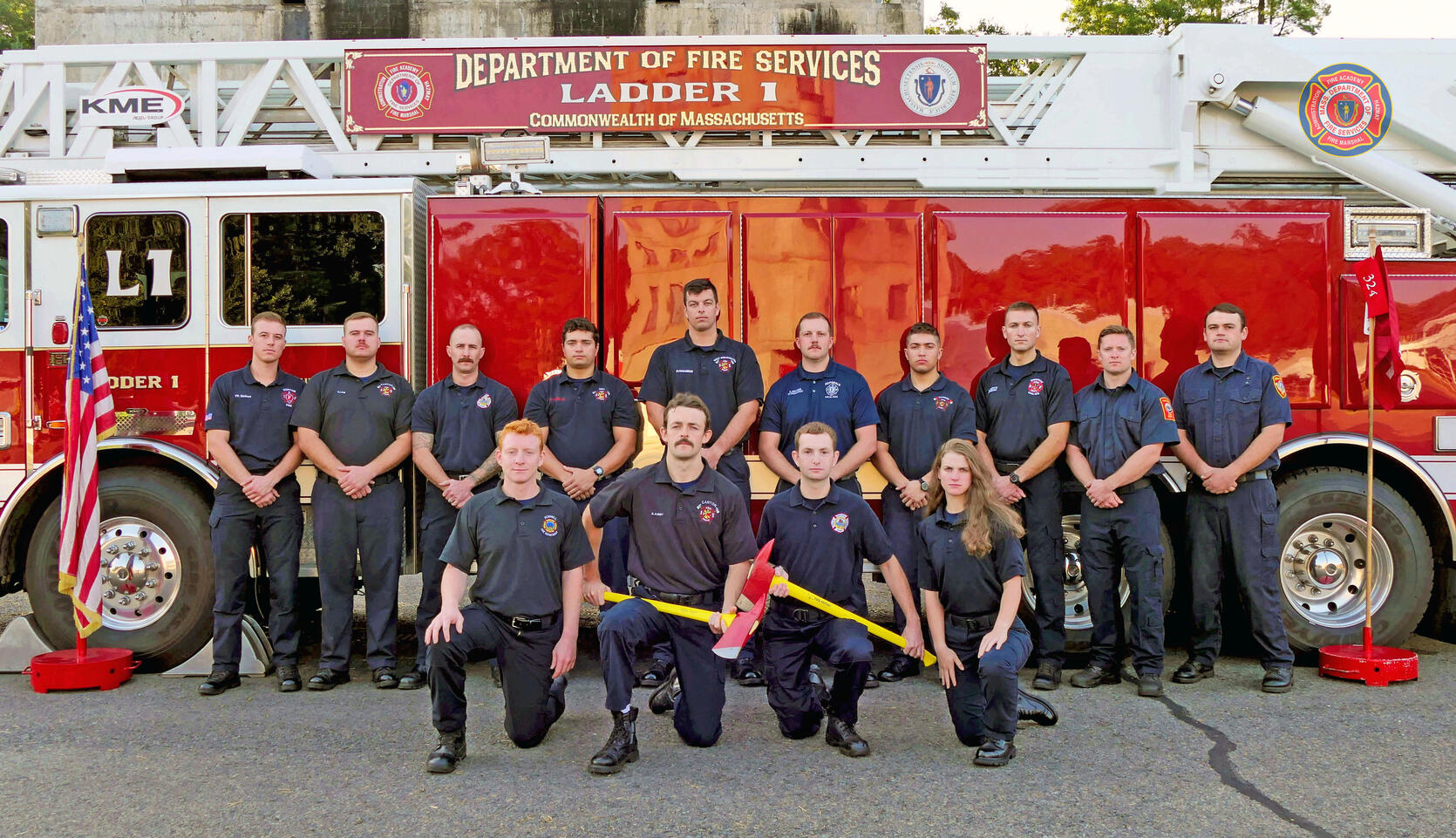 13 firefighters in front of a ladder truck