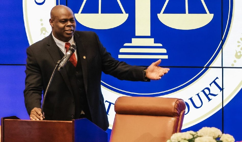 A man standing at a podium gestures while speaking.
