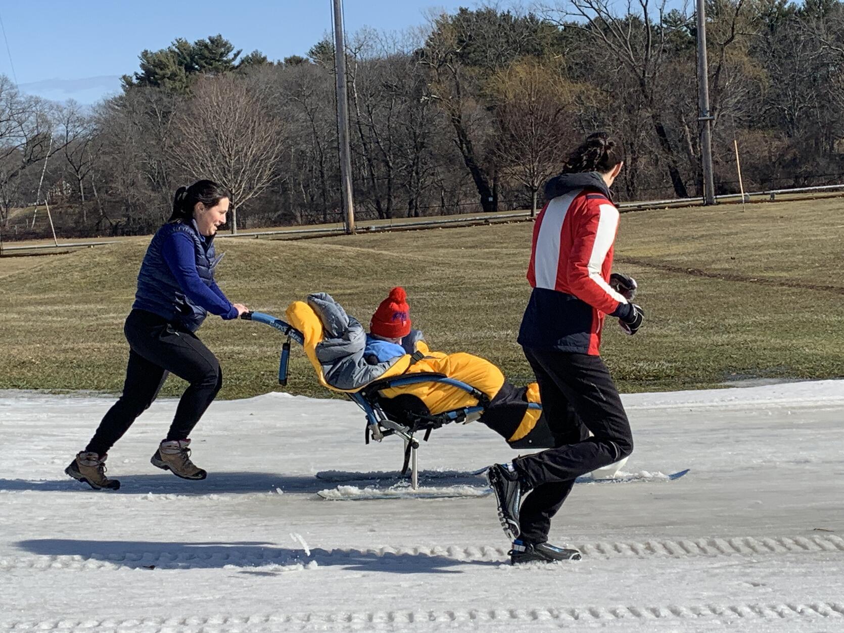 A sitskier being pushed across the snow.