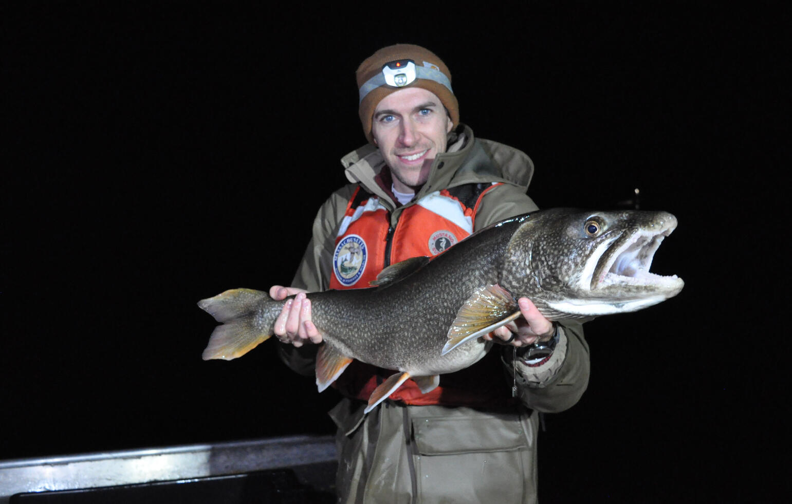 masswildlife biologist holding a large lake trout