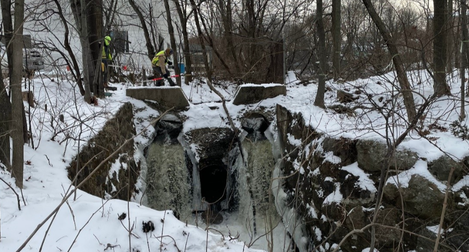 Staff looking at dam in winter.