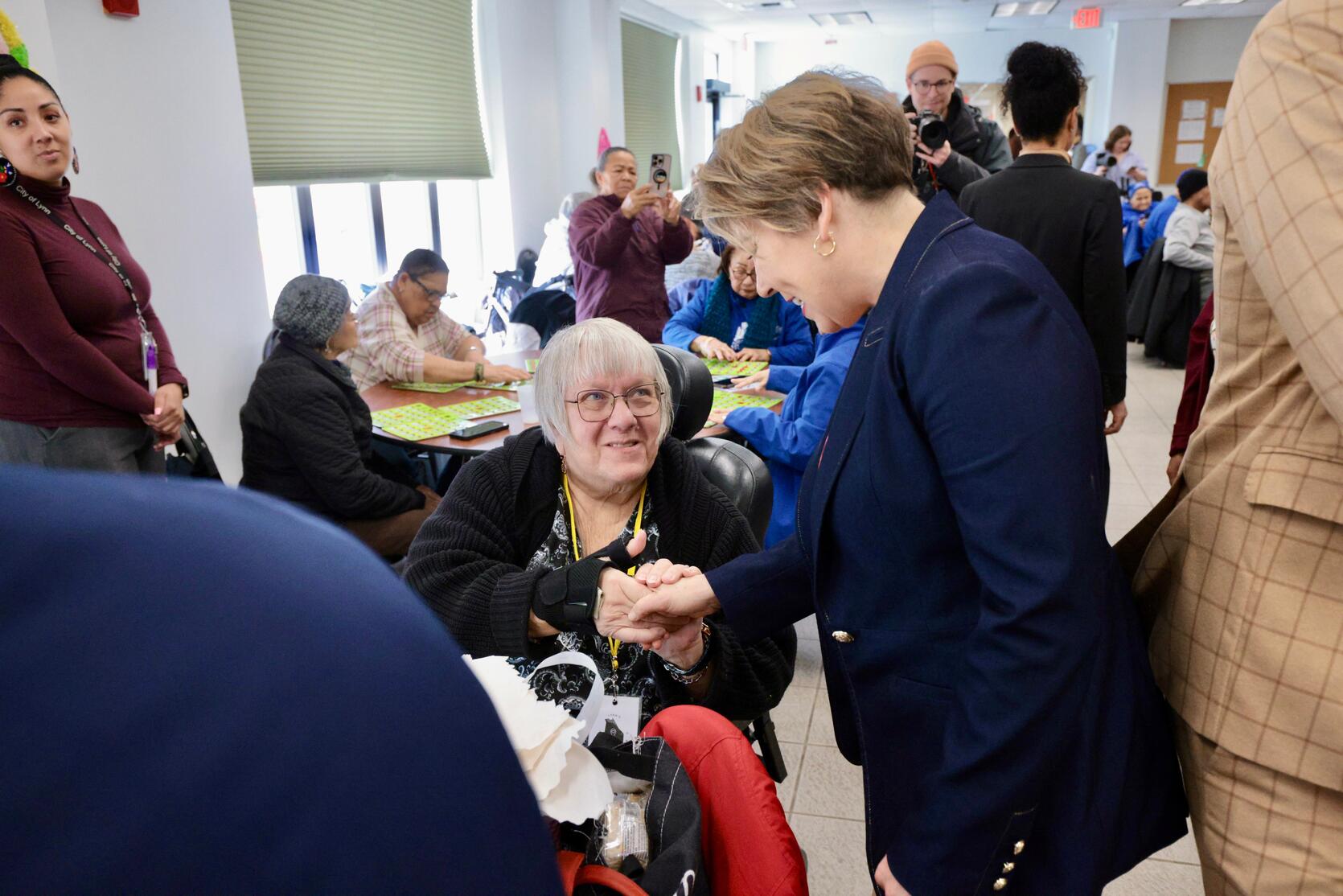 governor healey shaking hands with a senior resident playing bingo