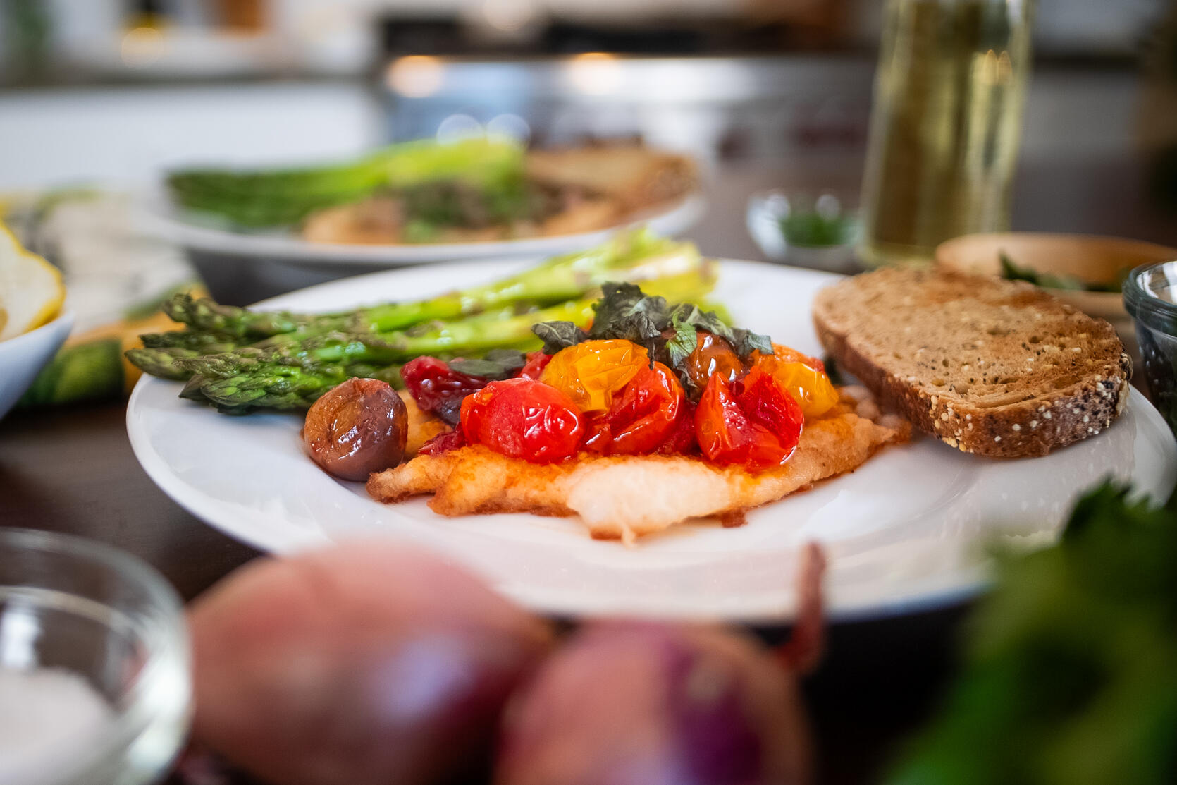 A plate of pan-seared sole with cherry tomato and caper-shallot toppers.
