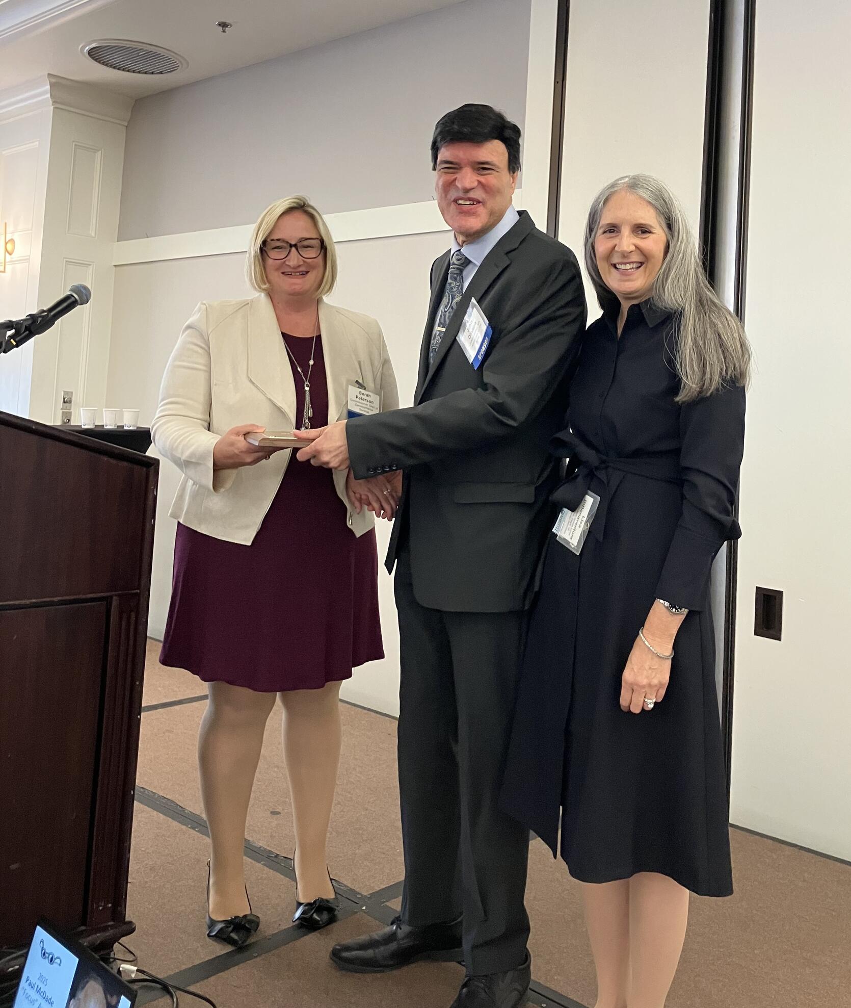 MCB Commissioner John Oliveira receives the "Focus" Award from DDS Commissioner Sarah Peterson and DDS Statewide Director for Vision and Vision Loss Services, Lisa DiBonaventura