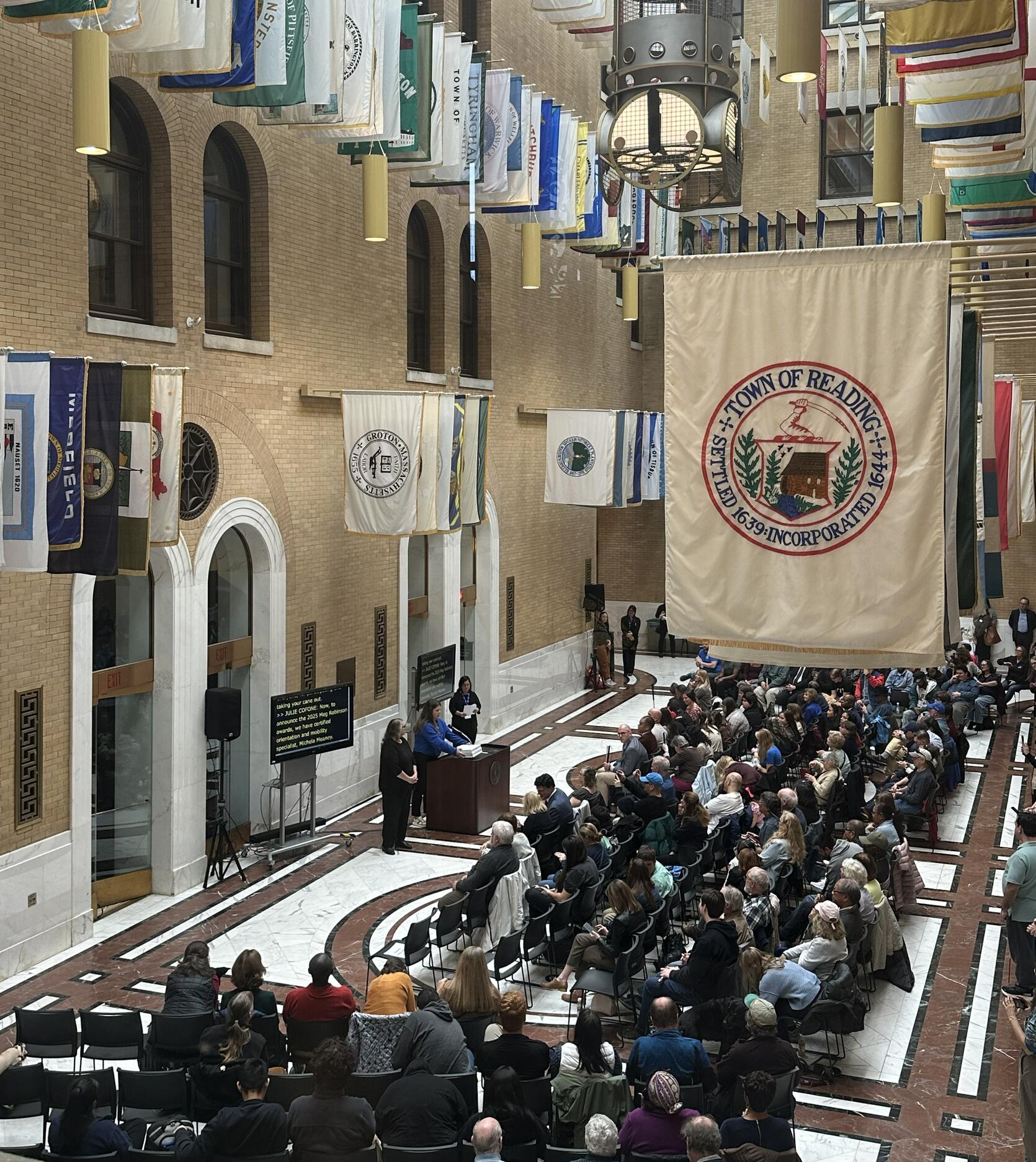 The large crowd both seated and standing in the Hall of Flags at the Massachusetts State House