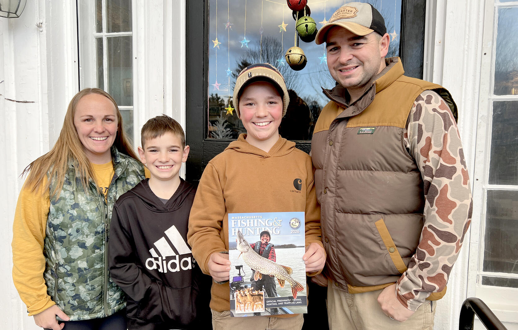 young angler and his family pose with fishing and hunting guide cover
