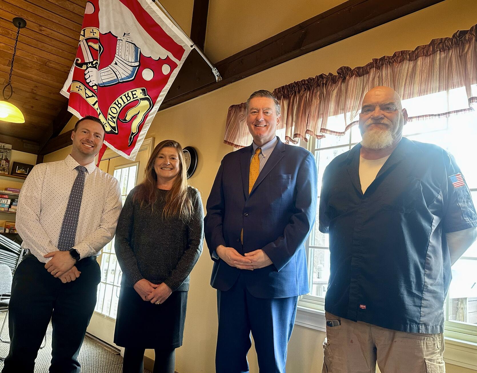 Secretary Ed Augustus stands with officials from Bedford at the Bedford Housing Authority in 2025.