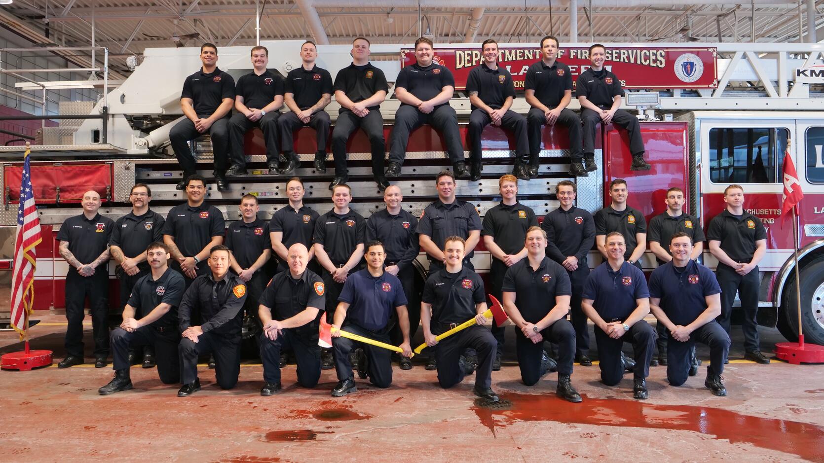 New firefighters on and around a ladder truck