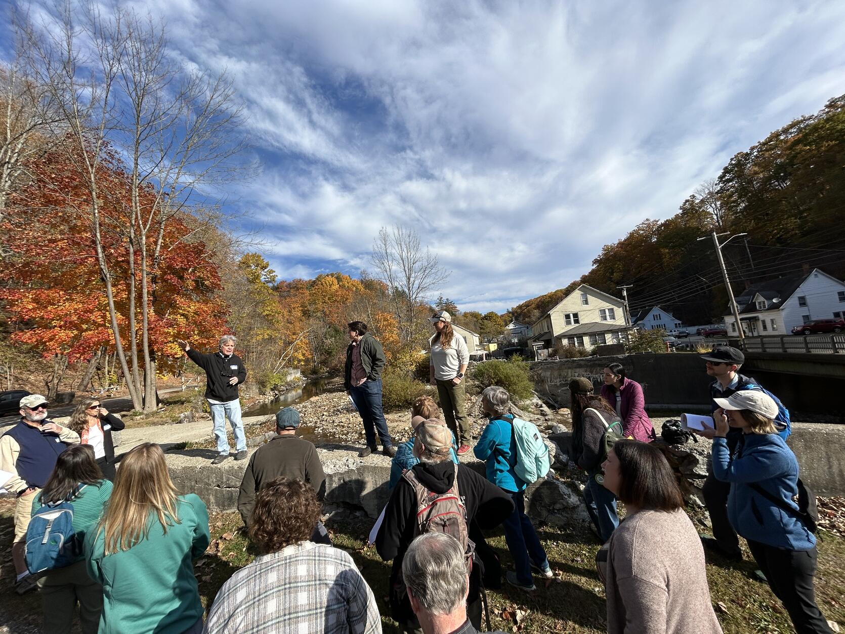 People stand in a group near a dam removal site.