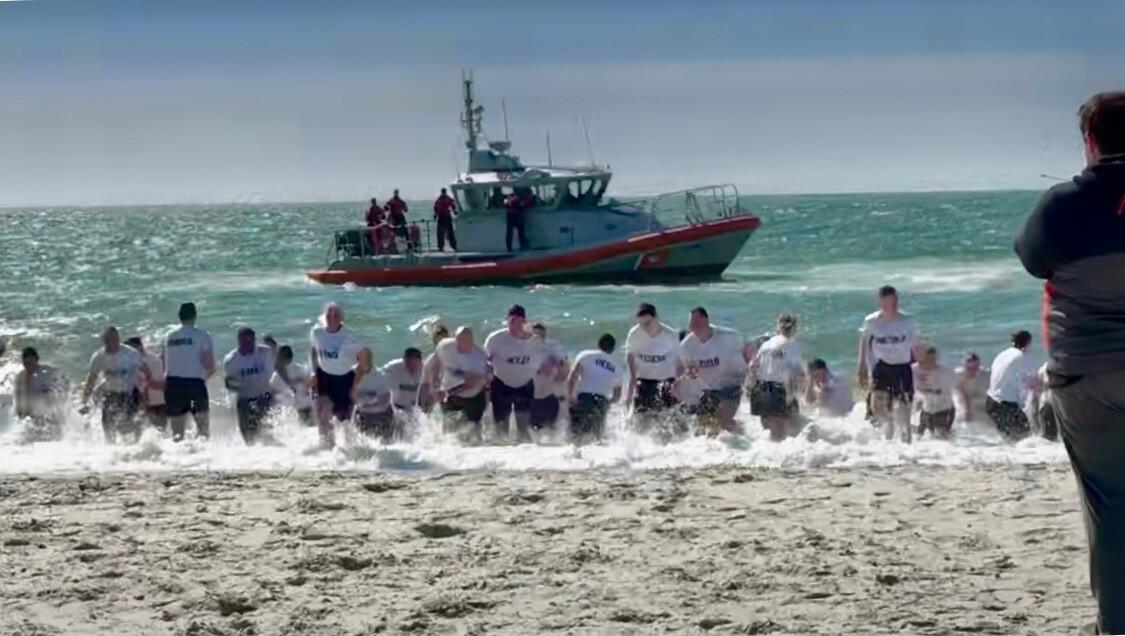 Student officers running out of the ocean water at a polar plunge event.