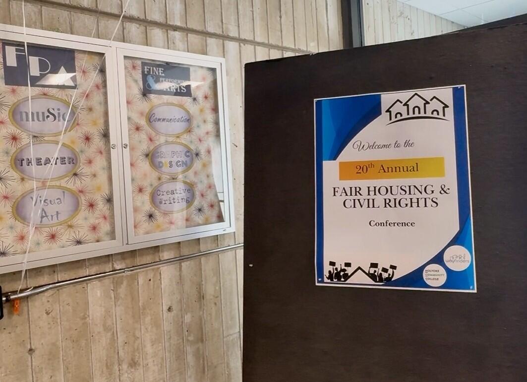 A sign hands on a wall welcoming people to the 20th annual Fair Housing & Civil Rights conference