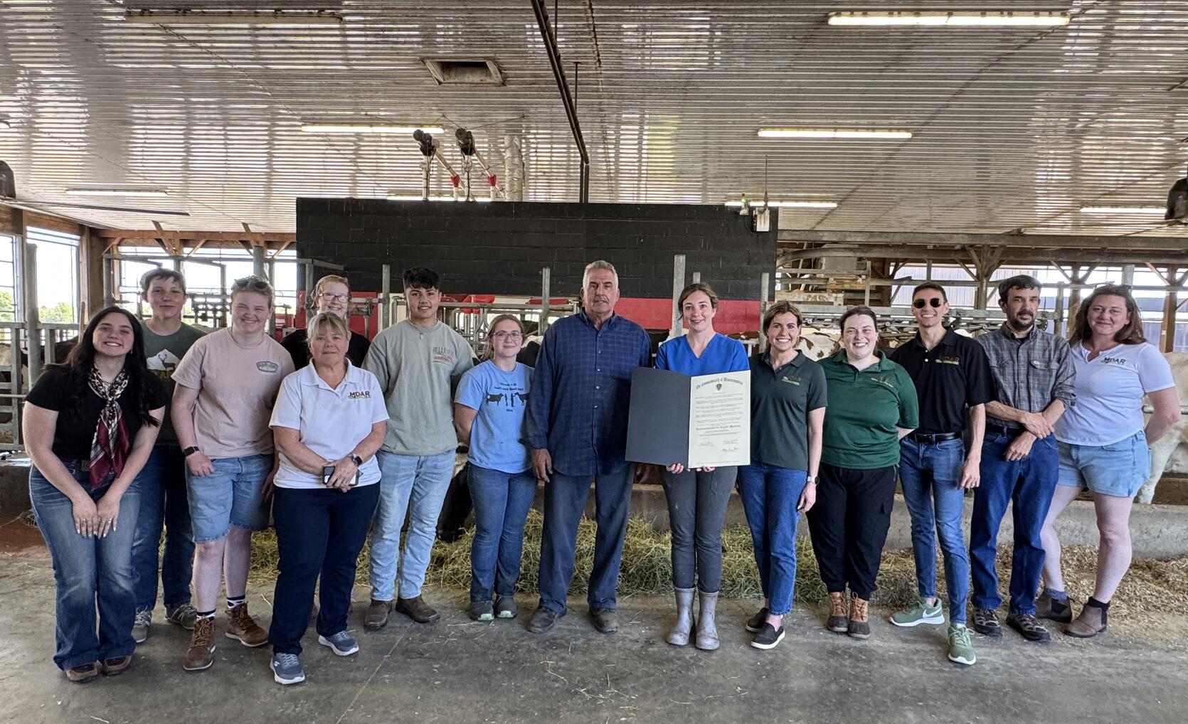 Commissioner Randle presents a Governor’s Proclamation to Herd Manager, Katelyn Lawrence and Farm Owner, Ed Almeida alongside MDAR Staff and members of the Agricultural Youth Council