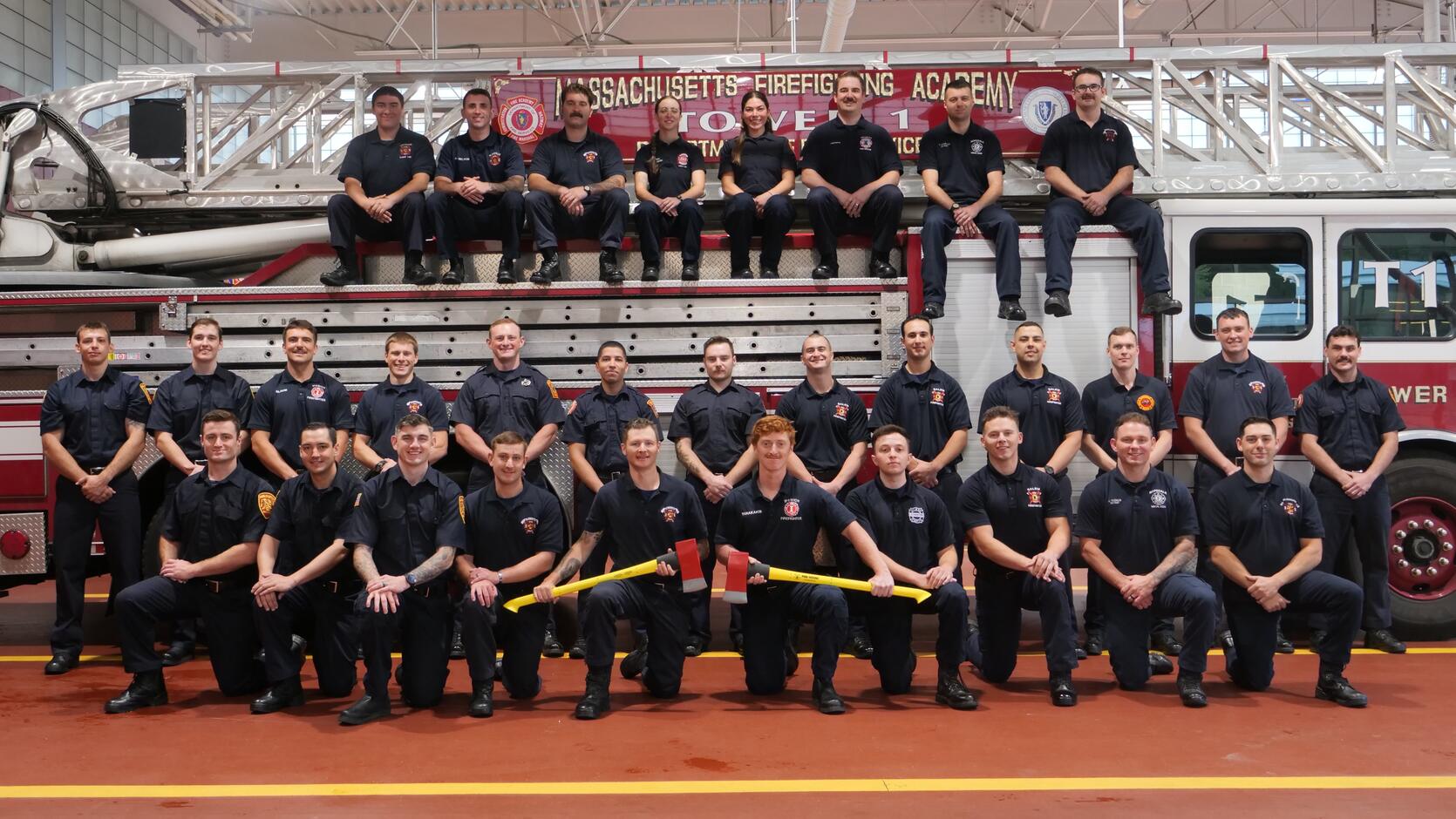 New firefighters on and around a ladder truck