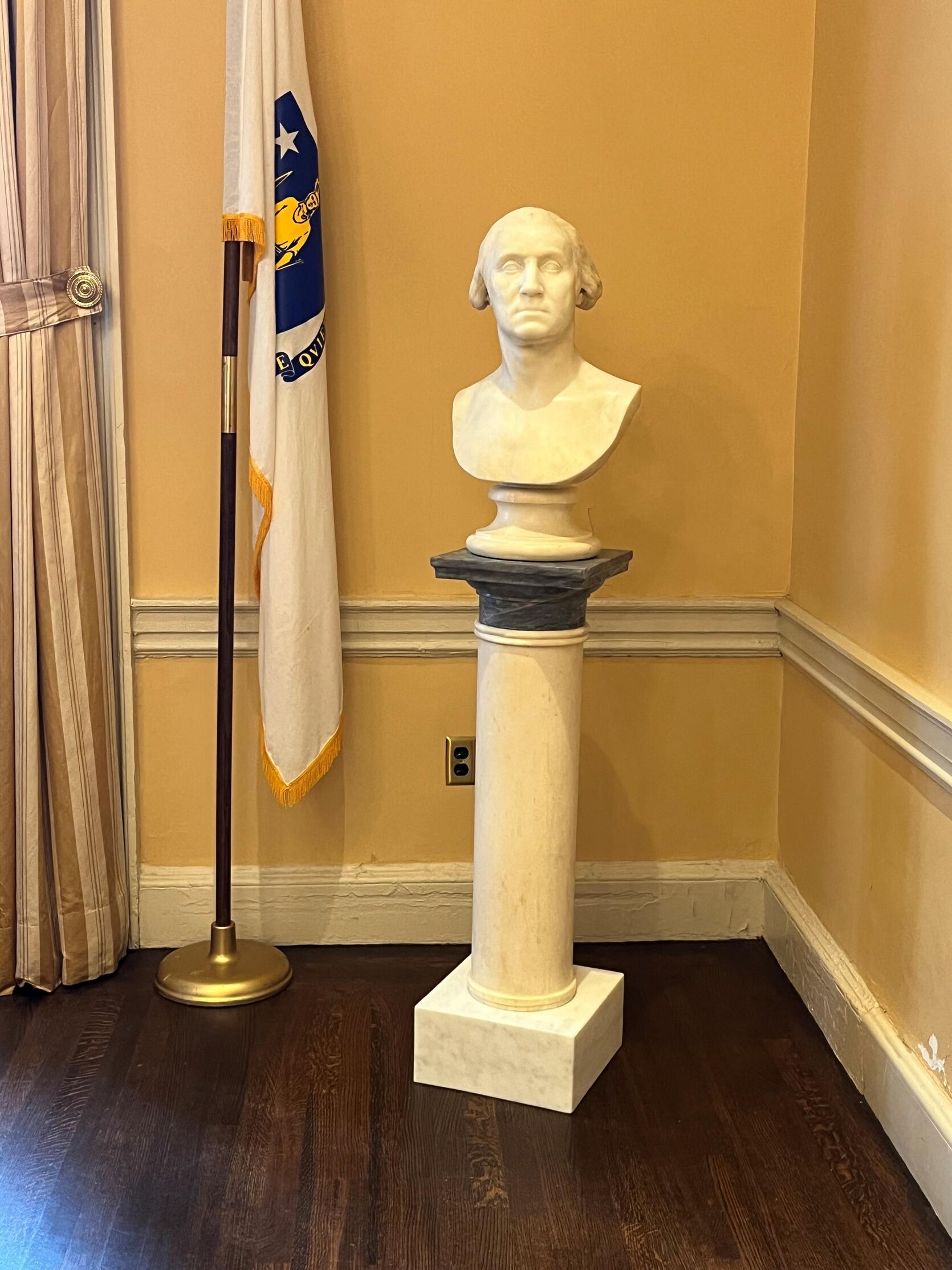 Marble bust of George Washington on a white and black pedestal