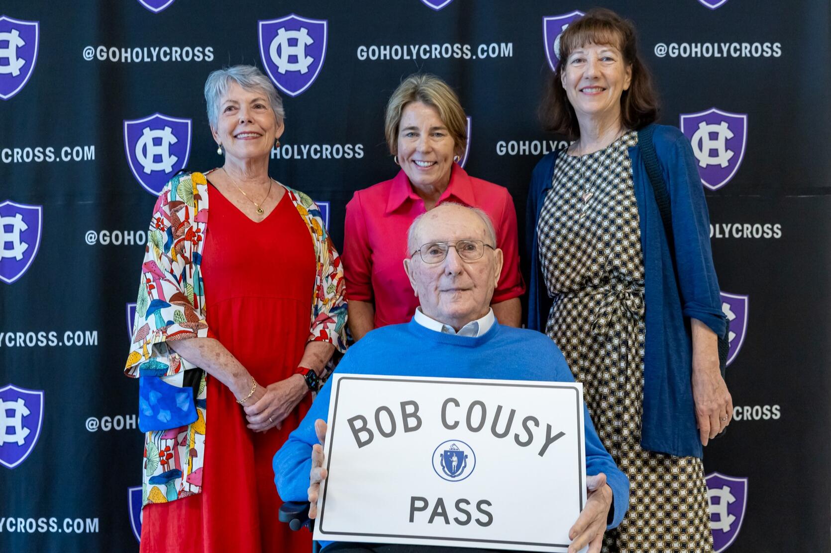 Governor Healey with Bob Cousy and his daughters with a sign saying "Bob Cousy Pass"