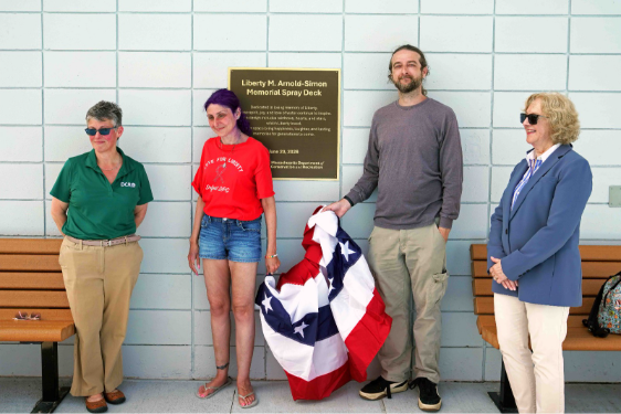four people standing by dedication sign