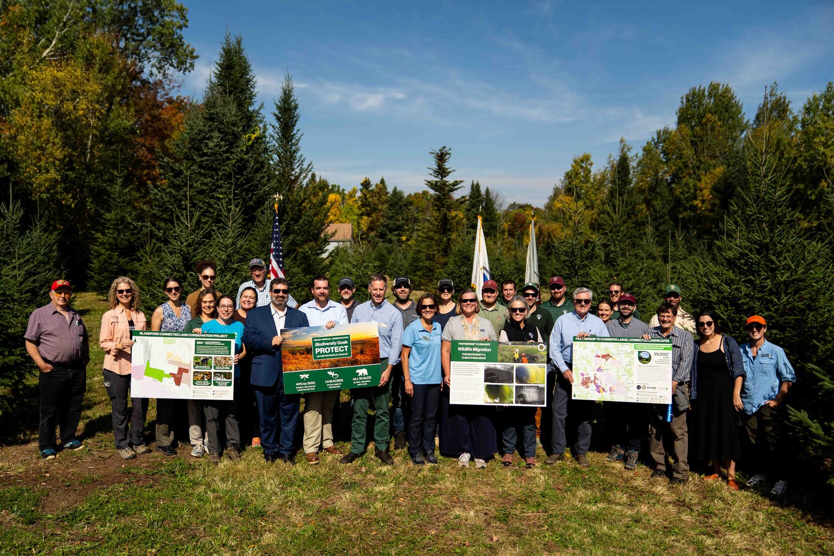 Group of people pose for a photo in field.
