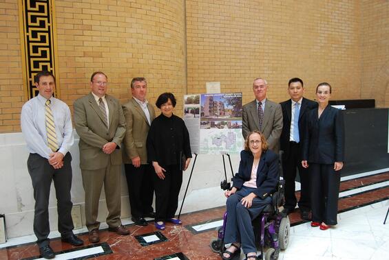 A group of people gathered around a display board.