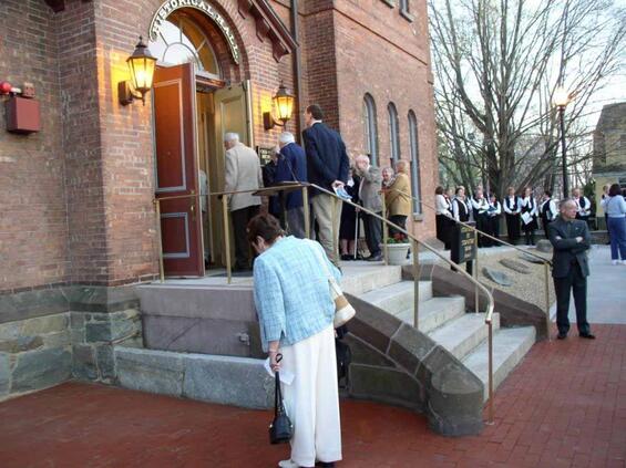 Exterior entrance to a brick building consisting of a staircase and ramp.