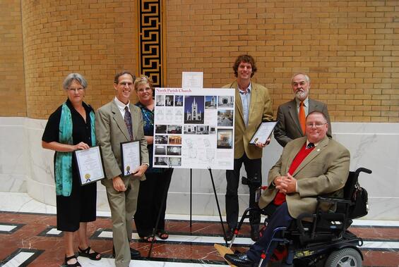 A group of people gathered around the display board