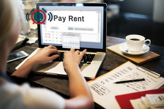 Person at computer with a calendar reminder alerting them that it is time to pay rent