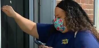 Person knocking on a door with "Trust the Facts, Get the Vax" materials.